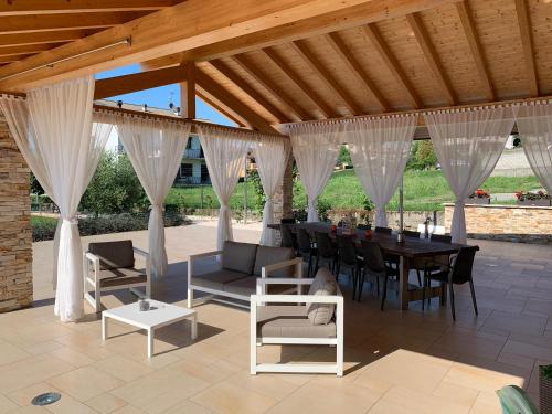 a patio with a table and chairs and a wooden ceiling at B&B Alciliegio in Casnate con Bernate