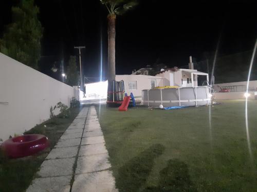 un cortile di notte con una casa e una palma di Faliraki Holidays a Faliraki