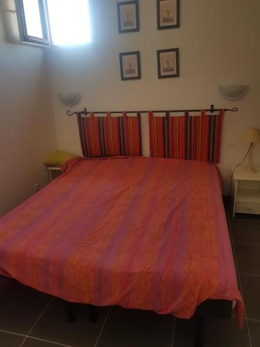 - une chambre avec un grand lit et une couverture colorée dans l'établissement Appartement piscine golf, à Saint-Cyprien