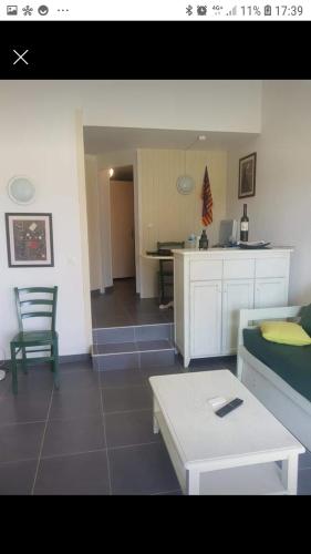 - un salon avec un canapé et une table dans l'établissement Appartement piscine golf, à Saint-Cyprien