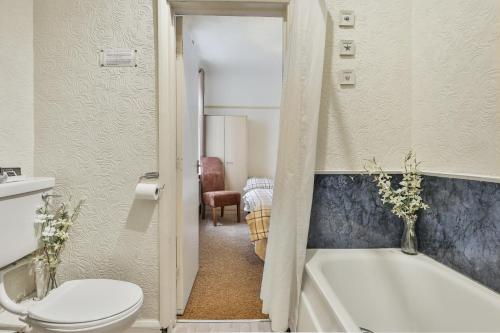 a bathroom with a toilet and a bath tub at Chomley holiday flats in Scarborough