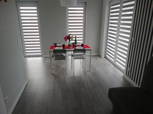 a dining room with a red table and chairs at MARKAS in Rewa