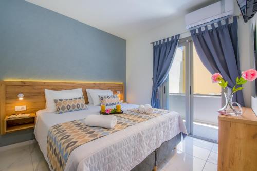 a bedroom with a large bed with blue walls at Linda Apartments Platanias in Plataniás