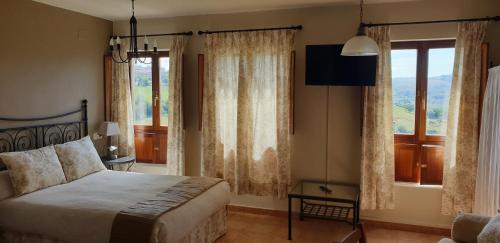 a bedroom with a bed and a large window at Apartamentos La Panerona in Tineo