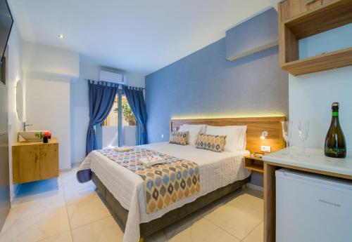 a bedroom with a bed with blue walls at Linda Apartments Platanias in Plataniás