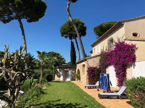 a garden with two chairs and a house at Magnifique Villa de prestige Antibes/Juan-les-Pins in Antibes