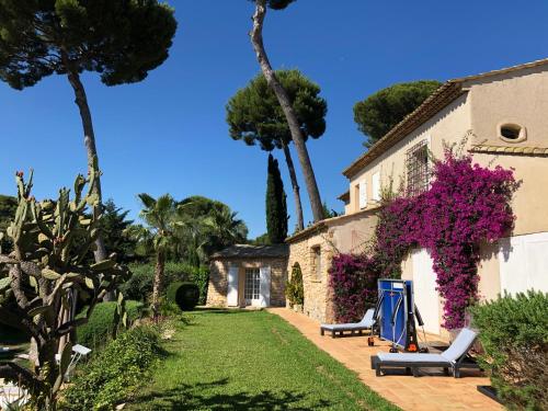 un jardin avec deux chaises et une maison dans l'établissement Magnifique Villa de prestige Antibes/Juan-les-Pins, à Antibes