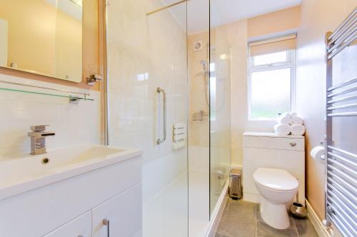 a bathroom with a toilet and a sink and a shower at Seaview - Cheviot Court in Broadstairs