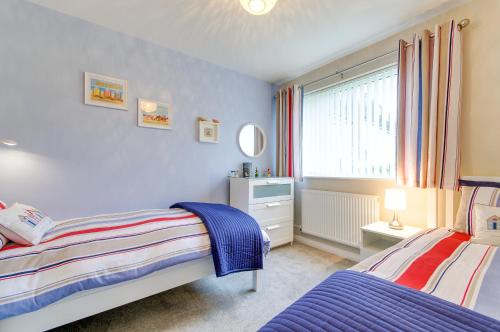 a bedroom with two beds and a window at Seaview - Cheviot Court in Broadstairs