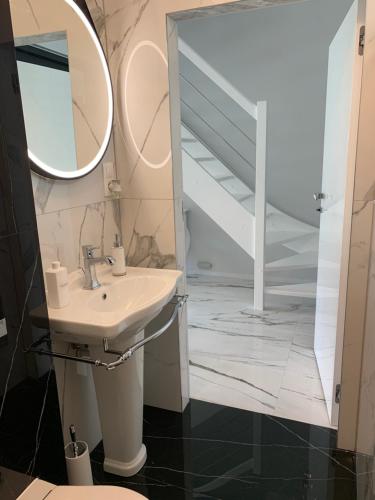 a bathroom with a sink and a mirror at Leo Royal Apartament Pobierowo in Pobierowo