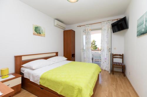 - une chambre avec un lit et une télévision murale dans l'établissement Apartman Meira br 2, à Mimice