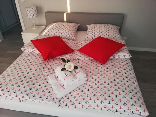 a bed with red pillows and a bedspread with aeddy bear on at MARKAS in Rewa