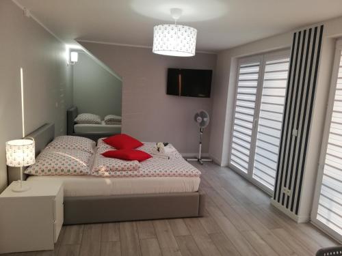 a bedroom with a bed with red pillows at MARKAS in Rewa