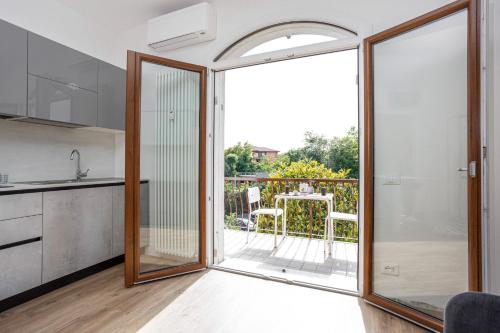 cocina con puertas correderas de cristal que dan a un balcón en Appartamento Perla, en Peschiera del Garda