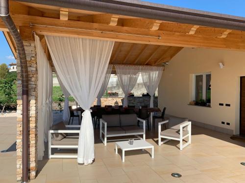 a pavilion with white curtains and a living room at B&B Alciliegio in Casnate con Bernate