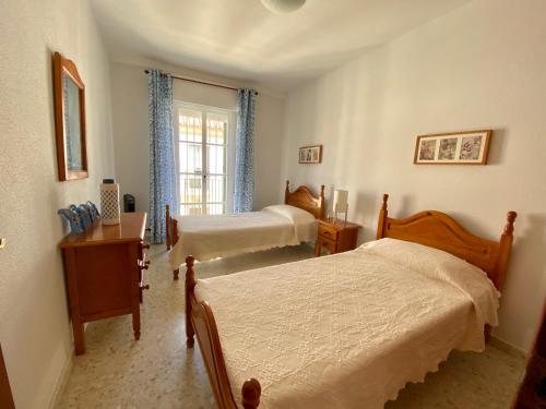 Giường trong phòng chung tại Chipiona/casa adosada/céntrico+playa/5plazas/garaje/