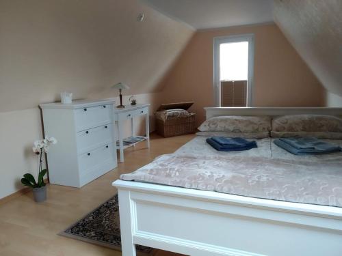 a bedroom with a white bed and a white dresser at Lootsi puhkemaja in Kuressaare
