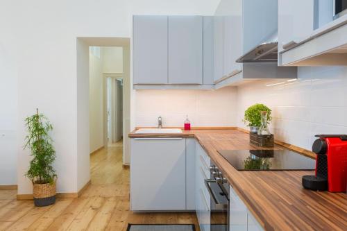 a kitchen with white cabinets and a sink at Dal Dottore in Corfu Town