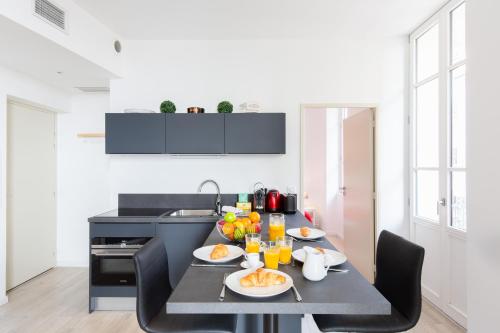 uma cozinha com uma mesa com pratos de comida em Astoux YourHostHelper em Cannes