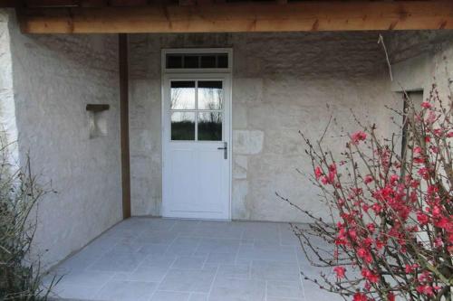 uma porta branca com uma janela numa casa de pedra em Gîte La Garauderie em LʼÎle-dʼElle