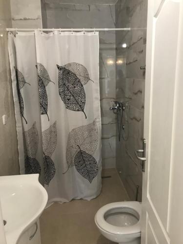 a bathroom with a shower curtain with umbrellas on it at Vila Luka in Slano