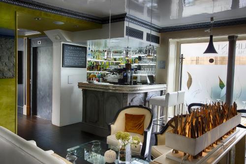 Cette chambre dispose d'un bar avec une table et des chaises. dans l'établissement Eiffel Trocadéro, à Paris