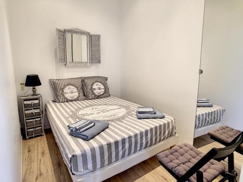 ein Schlafzimmer mit einem Bett, einem Stuhl und einem Spiegel in der Unterkunft Hanna-Logis in Antibes