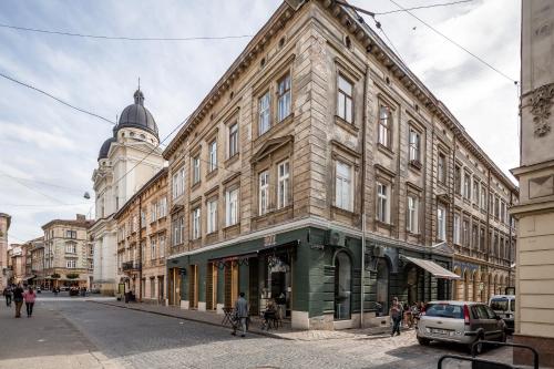 a large building on a city street with a clock tower at Apartment On Yana Zhizhky in Lviv