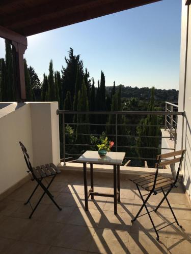 a patio with a table and two chairs on a balcony at Demelida Villa in Tsada, Paphos in Tsadha