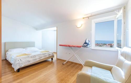 Un dormitorio blanco con una cama y una ventana. en Apartman Relax, en Podstrana