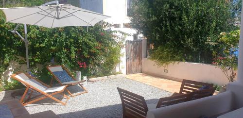 a patio with two chairs and an umbrella at Villa Euribia in Santa Marina Salina