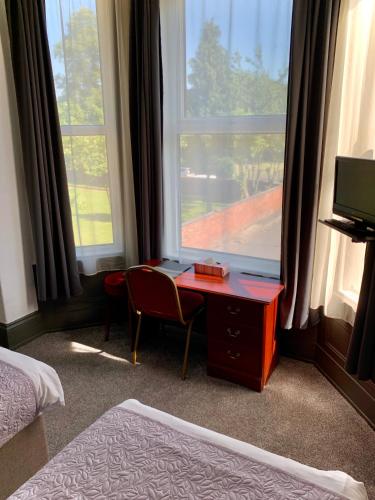 a bedroom with a desk in front of a window at Manchester Stay Hotel - Free Parking in Manchester