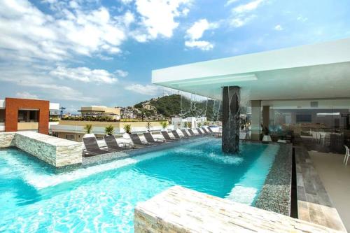 a swimming pool with lounge chairs and a building at Skyloftpv by LOFT268 in Puerto Vallarta