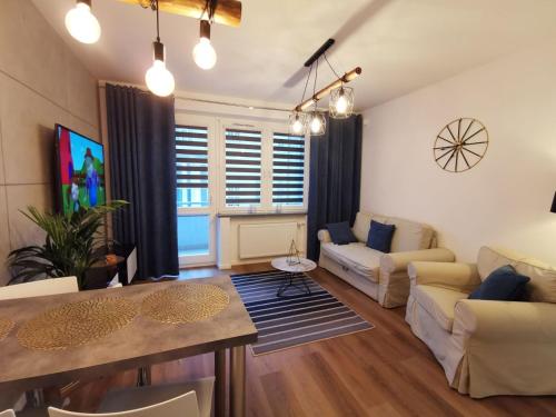 ein Wohnzimmer mit Sofa und Tisch in der Unterkunft Apartament Platynowy w Centrum Miasta in Częstochowa