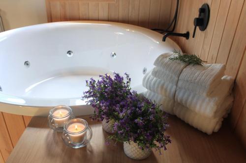 y baño con bañera con velas y flores púrpuras. en Casa la Era, en Sahún