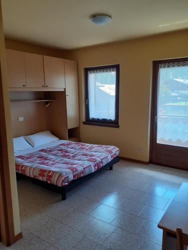 a bedroom with a bed and a large window at Residence Iris BeB in Valdisotto