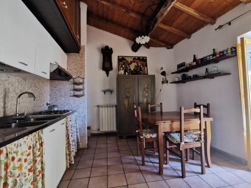 アリッチャにあるCasa Con Soppalco ad Aricciaのキッチン(木製テーブル、椅子付)