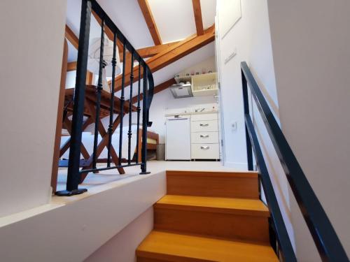 - un escalier dans une maison aux murs blancs et en bois dans l'établissement Antiche Mura, à Rovinj