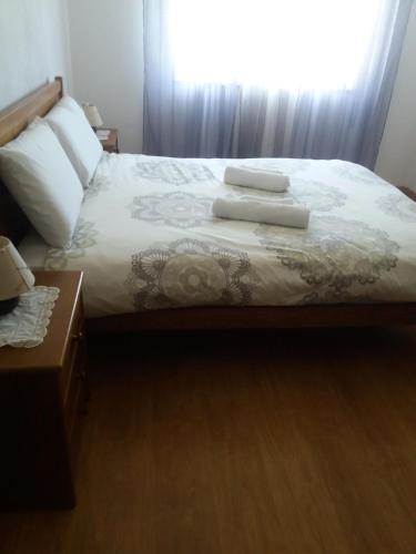 a bedroom with a bed with two pillows and a window at Belamandil Garden ,family holidays ,caminho do torrejao olhao in Olhão