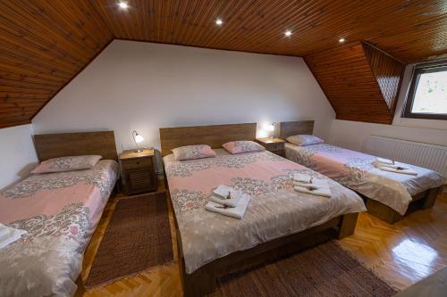 una camera da letto con due letti con asciugamani sopra di Maison ALANA a Divčibare