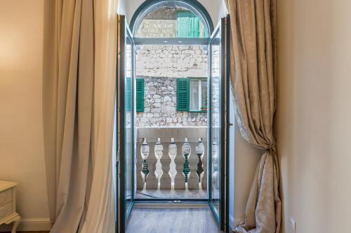 - une porte en verre dans une pièce dotée d'un mur en pierre dans l'établissement Palace of Dreams Rooms, à Split