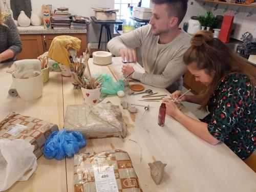 a man and a woman sitting at a table making bags at Agroturystyka Hanka i Jurek in Boruja