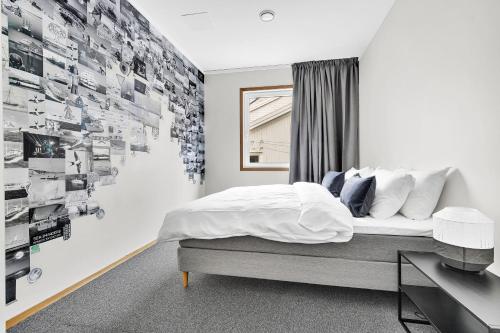 a bedroom with a bed and a wall of pictures at Lille Hotell in Arendal