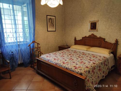 a bedroom with a bed and a chair and a window at Around Rome in Marino
