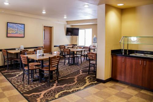 a restaurant with tables and chairs and a television at Richland Inn and Suites in Sidney