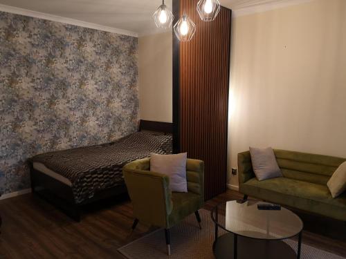 a living room with a couch and a bed at Apartament Złoty w Centrum Miasta in Częstochowa