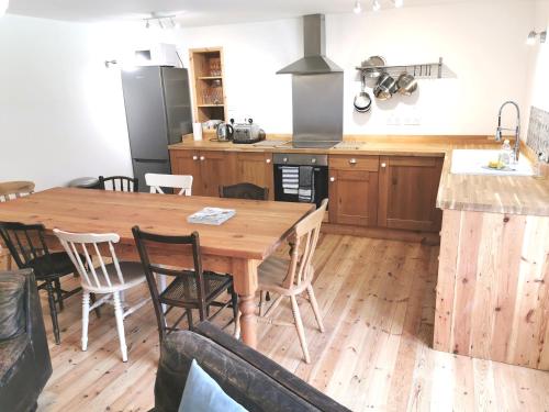 a kitchen with a wooden table and some chairs at THE OLD RECTORY GLEBE HOUSE in Jacobstow 10 mins to Widemouth bay and Crackington Haven,15 mins Bude,20 mins tintagel, 27 mins Port Issac in Bude