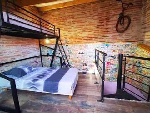 a bedroom with a bunk bed in a brick wall at Maison Small Luxury ( planxa,suite,solarium,jacuzzi,pas de vis à vis) in Argelès-sur-Mer