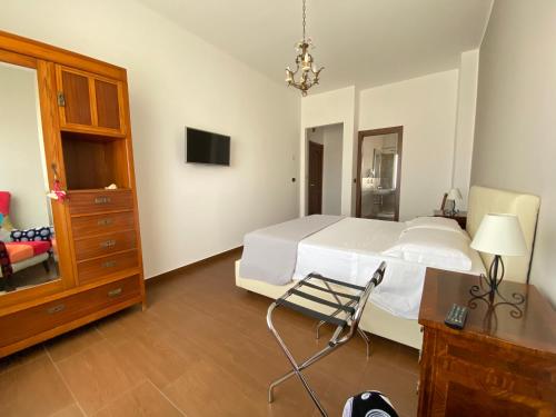 1 dormitorio con cama, escritorio y silla en Panoramic Rooms, en Siracusa