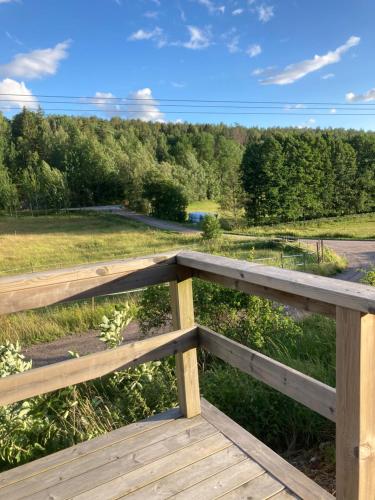 a wooden fence with a view of a field at Asplunda Gård, Kolmården stuga nr 1 in Kolmården
